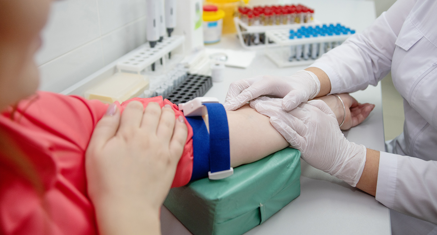 phlebotomy tech holding patients arm